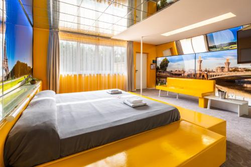 a yellow room with a bed and a tv at Motel Autosole Vip in Castelnuovo Scrivia