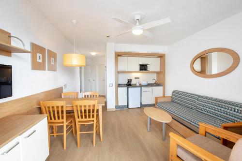 a living room with a couch and a table and chairs at Aguamar Apartamentos, Los Cristianos Downtown in Los Cristianos