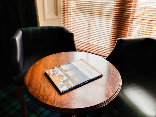 a book sitting on top of a wooden table at Lost Guest House Stirling in Stirling