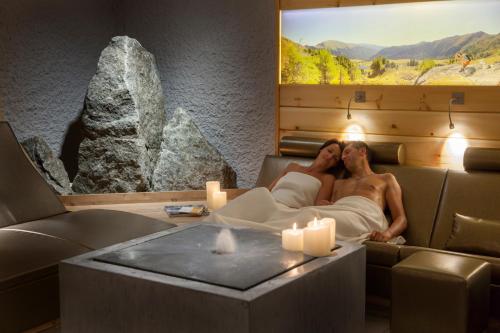 a man and woman laying in a room with candles at Das Ronacher Therme & Spa Resort in Bad Kleinkirchheim