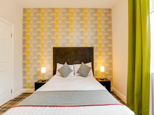 a bedroom with a large bed with two night stands at Lost Guest House Stirling in Stirling
