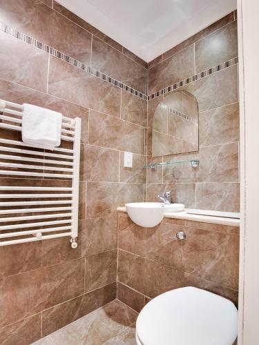 a bathroom with a toilet and a sink at Lost Guest House Stirling in Stirling
