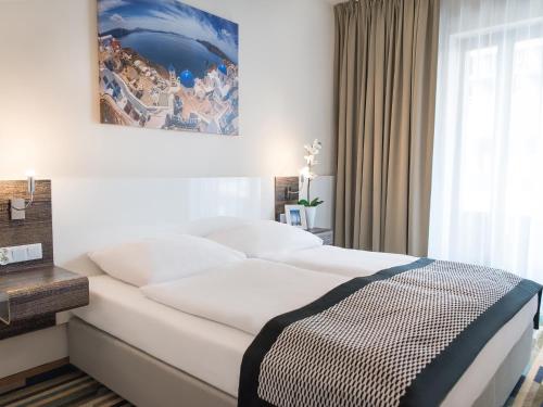a bedroom with a large white bed and a window at VacationClub - Baltic Park Molo Apartment C109 in Świnoujście