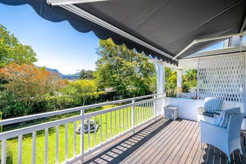 a porch with a blue chair and a view at Oude Berg Guesthouse - 10 Caledon Street in George