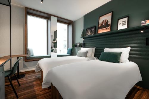 duas camas num quarto com paredes verdes em A-STAY Antwerp em Antuérpia