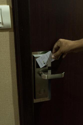 a person holding a piece of paper in a door at HOTEL PARK VICTORIA in Kolkata