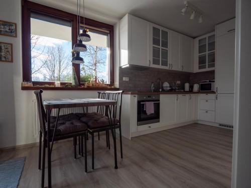 eine Küche mit weißen Schränken sowie einem Tisch und Stühlen in der Unterkunft Apartmán Lopi in Tatranská Lomnica
