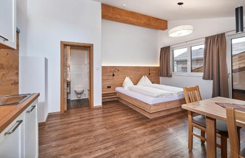 フラッハウにあるAppartment Ransburggutのベッドとテーブルが備わるホテルルームです。