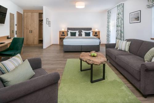 a living room with a couch and a bed at Hotel Obermaier in Munich