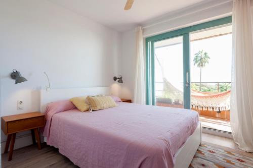 a bedroom with a bed and a large window at Gavamar Castelldefels Beachfront Apartment- Direct access to the beach in Gavà