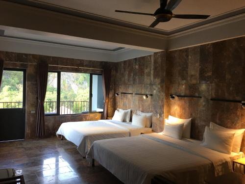 a bedroom with two beds and a ceiling fan at Limestone View Homestay in Ninh Binh