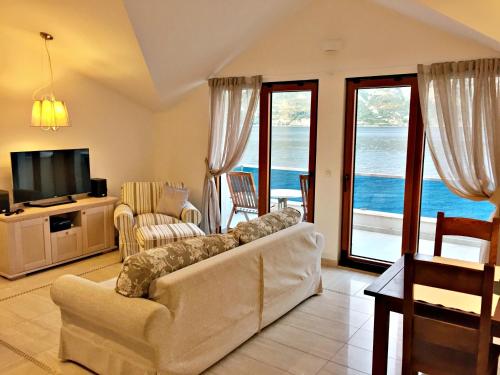 a living room with a couch and a tv at Apartment MiraMare in Kotor