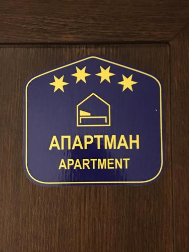 a sign for an apartment apartment on a wooden door at SLAVNA - Luxe & Wine by the Fortress in Belgrade