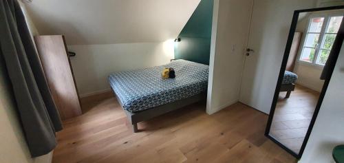małą sypialnię z łóżkiem i lustrem w obiekcie Appartement Studio Prieuré w mieście Quimper