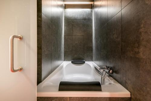 a bath tub in a bathroom with a sink at Argulls by Totiaran in Naut Aran