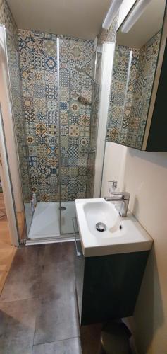 a bathroom with a shower and a sink and a tub at Appartement Studio Prieuré in Quimper