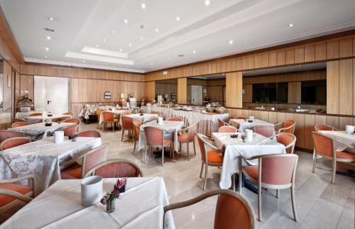 um restaurante com mesas e cadeiras num quarto em Hotel Fortuna em Ancona