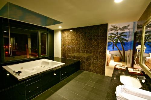 La salle de bains est pourvue d'une grande baignoire et d'un lavabo. dans l'établissement Fair Tale Motel - Sea, à Hualien