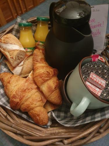 un cestino di pasticcini e una caffettiera con caffè e succo di frutta di Appartement Studio Prieuré a Quimper