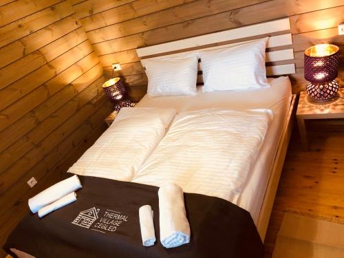 a bedroom with a bed with two towels on it at Club Thermal Village Cegled in Cegléd