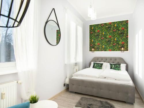 a bedroom with a bed and a large painting on the wall at VacationClub – Poleska 4C Apartament 7 in Kołobrzeg