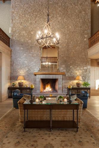 a living room with a fireplace and a chandelier at Santa Marina Arachova Resort & Spa in Arachova