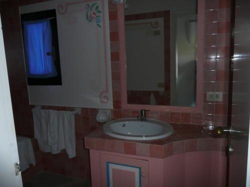 a bathroom with a sink and a mirror at Cormorani Alti in Baja Sardinia
