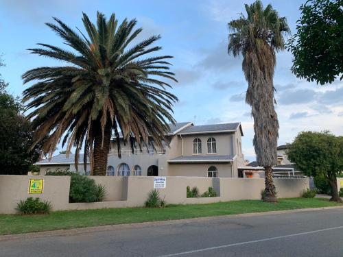 a house with two palm trees in front of it at Brackendowns guest star in Alberton