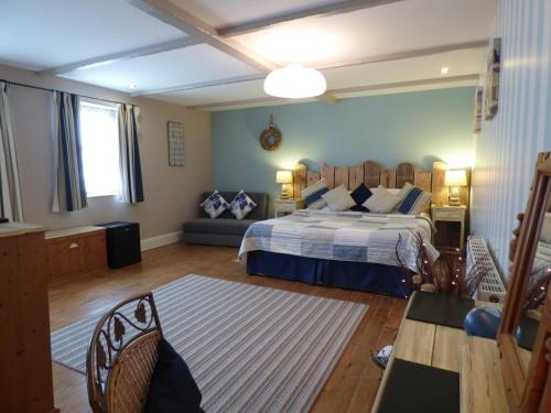 a bedroom with a large bed and a couch at The Cross Guest House in Mablethorpe