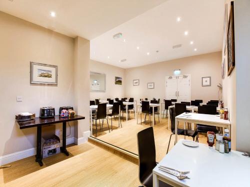 a dining room with tables and chairs and a mirror at Lost Guest House Stirling in Stirling