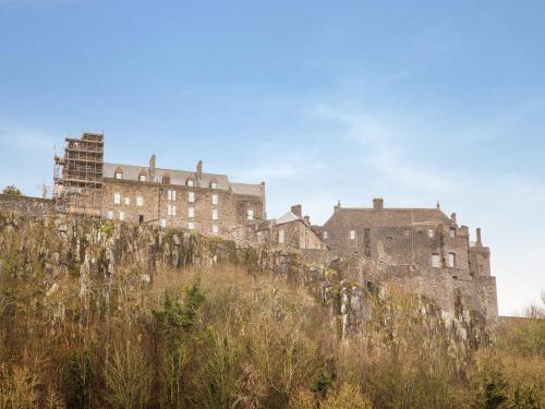 a castle on top of a hill with buildings at Lost Guest House Stirling in Stirling