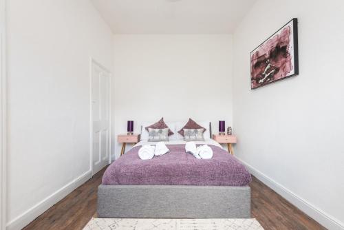 ein Schlafzimmer mit einem Bett mit einer lila Decke in der Unterkunft Modern, Romantic Apartment in York - Pass the Keys in York