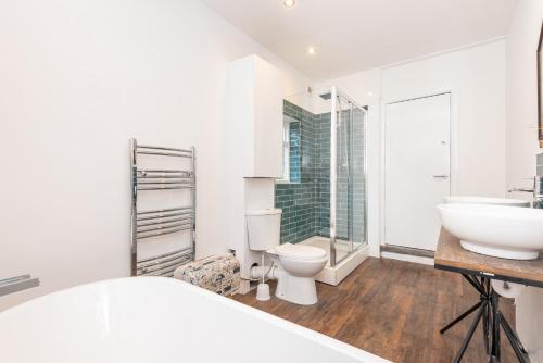 a white bathroom with a sink and a toilet at Modern, Romantic Apartment in York - Pass the Keys in York
