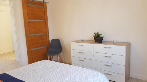 a bedroom with a bed and a dresser and a chair at Gite D'Elnon-Libre in Saint-Amand-les-Eaux