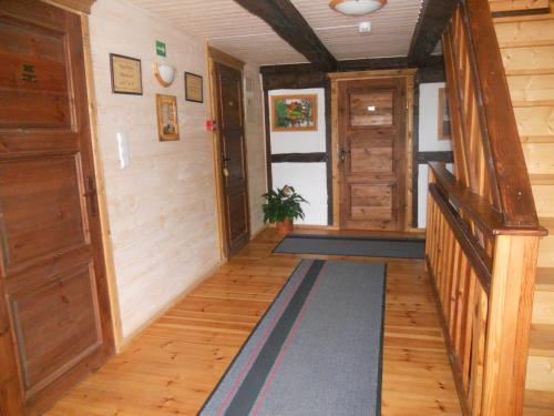 a hallway of a home with wooden floors and wooden doors at Dom Gościnny Matysowka in Jarosławiec