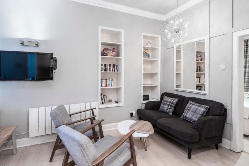 a living room with a couch and a tv at Ice Cream Suite in Edinburgh