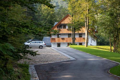 a house with a car parked on the side of a road at Bohinj Apartments Goldhorn Kingdom in Bohinj