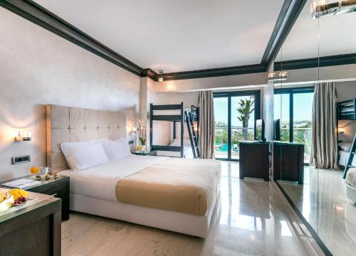 a bedroom with a large bed and glass walls at Mitsis Faliraki in Faliraki