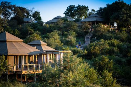 a house in the middle of a hill with trees at Simbavati Hilltop Lodge in Timbavati Game Reserve