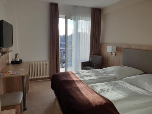 una camera d'albergo con letto, scrivania e finestra di Hotel Wetzlarer Hof a Wetzlar
