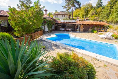 einen Pool in einem Hof mit einem Haus in der Unterkunft Къща за гости Пъстрина in Sŭbotkovtsi