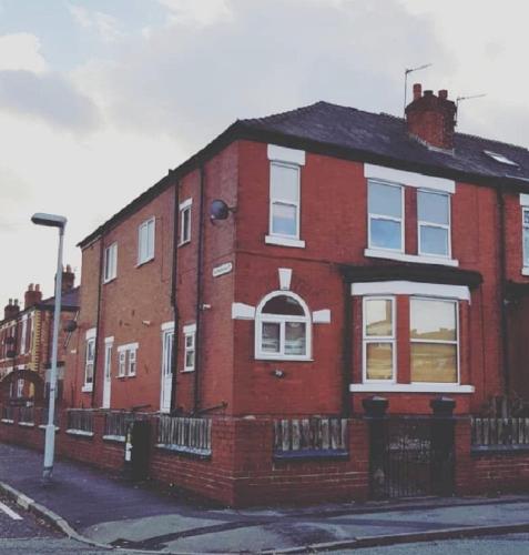 a red brick house on the side of a street at Beautiful 4 bedroom Victorian Apartment Sleeps 7 STOCKPORT in Manchester