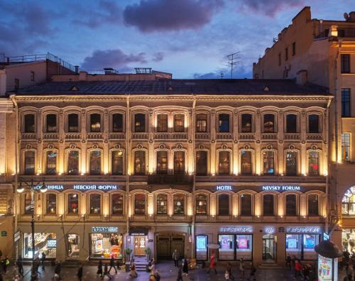 duży budynek w mieście w nocy w obiekcie Nevsky Forum Hotel w Petersburgu