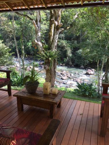 a wooden deck with a bench and candles on it at Pousada Vila do Loro in Domingos Martins