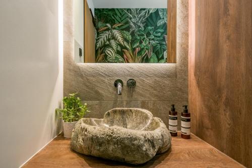 a bathroom with a large stone bowl in the corner at Hotel Obermaier in Munich