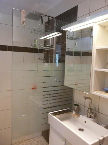 a bathroom with a sink and a glass shower at Les Lebes - La petite maison in Sempesserre