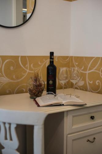 a bottle of wine sitting on a table with two glasses at Villa La Baia a pochi passi dal lago in San Felice del Benaco