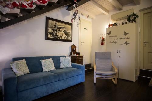a living room with a blue couch and a chair at Villa La Baia a pochi passi dal lago in San Felice del Benaco