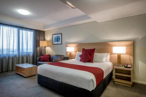 Habitación de hotel con cama grande y sofá en Bunbury Hotel Koombana Bay en Bunbury