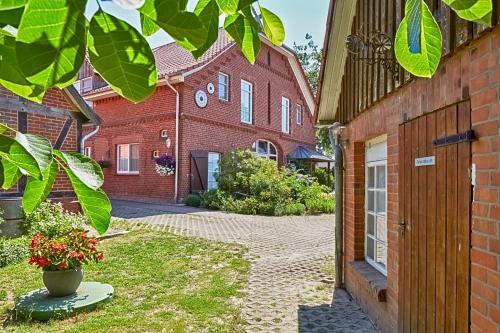 a brick building with a courtyard in front of it at Elbhof Harnisch in Bleckede